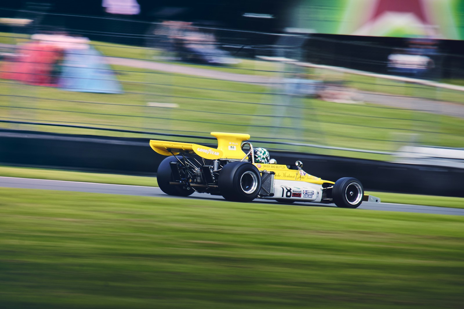 a yellow race car driving down a race track